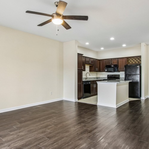 living room photo with ceiling fan and kitchen bar space