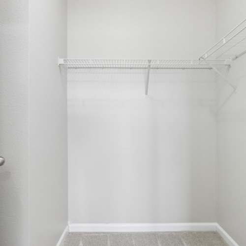 walk in closet with white walls