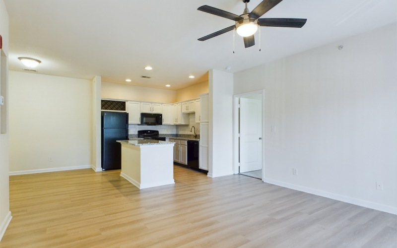 Spacious floorplans designed with you in mind living room with ceiling fan and kitchen with kitchen island